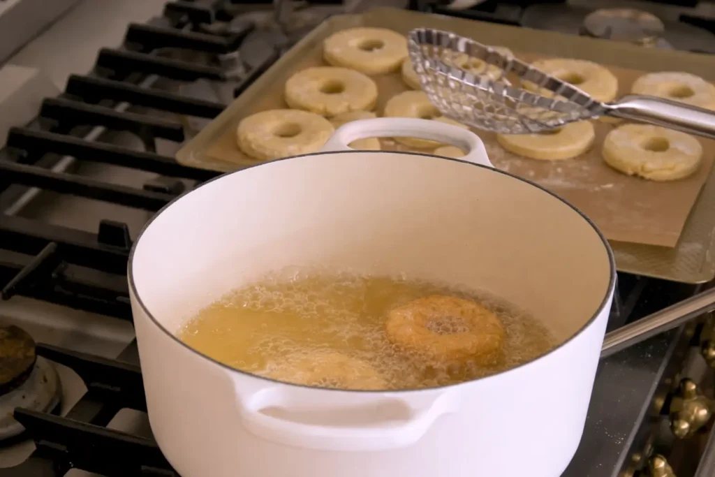 Frying old-fashioned sour cream donuts in oil until golden and crispy